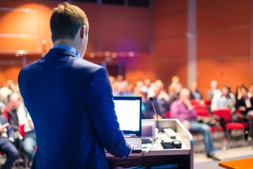 A speaker delivering a presentation at a conference